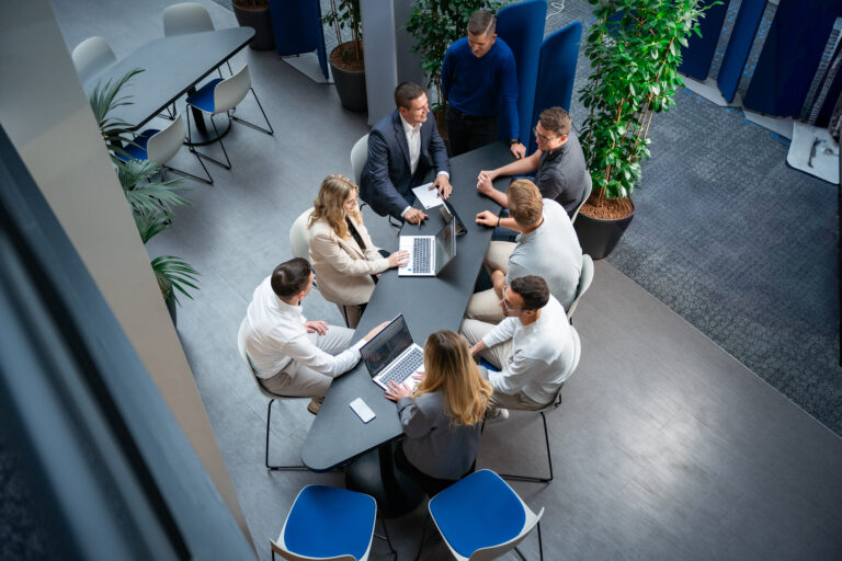 Menschen sitzen zusammen mit Laptops und unterhalten sich
