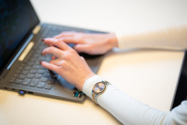 Hände, die auf einer Laptoptastatur tippen